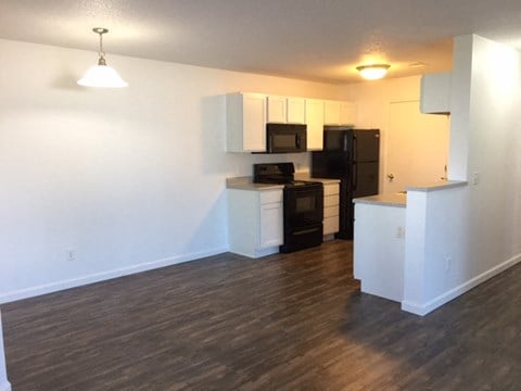 spacious dining room, bright white clean cabinets, wood flooring, premium countertops and appliances at regency apartments in Bettendorf Iowa